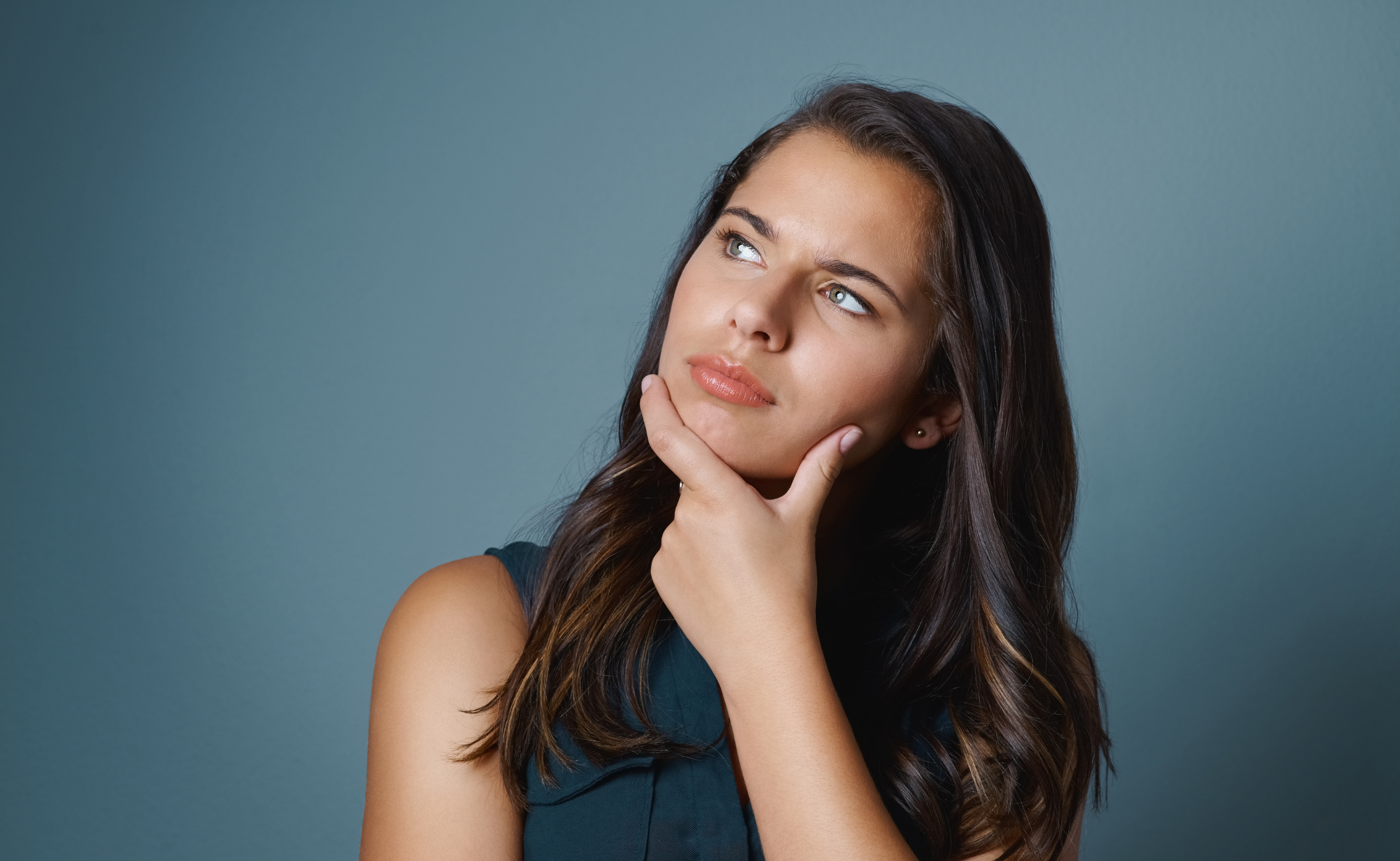 Woman with hand on her chin overthinking